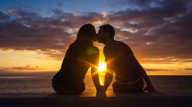 A close-up of a couple kissing, highlighting the risks of diseases transmitted through saliva.